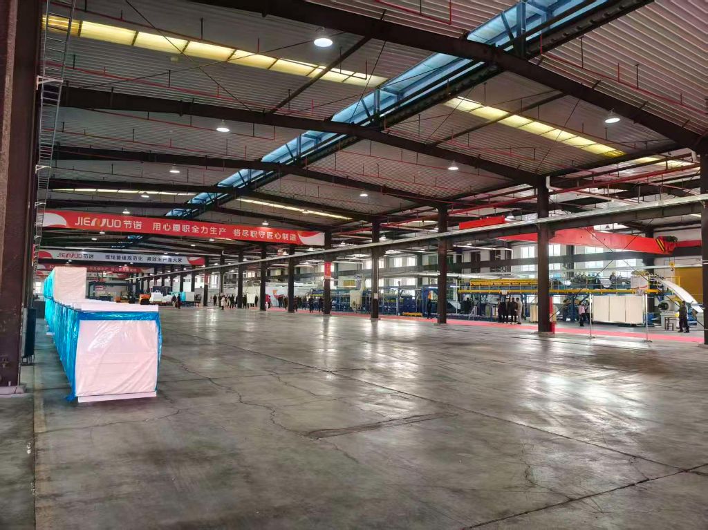 宽敞开阔的厂房内，地面平整光洁，自动化生产线沿纵深整齐排布，采光充足，动线清晰